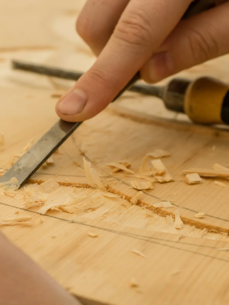 Woodcarver shaping timber with a chisel