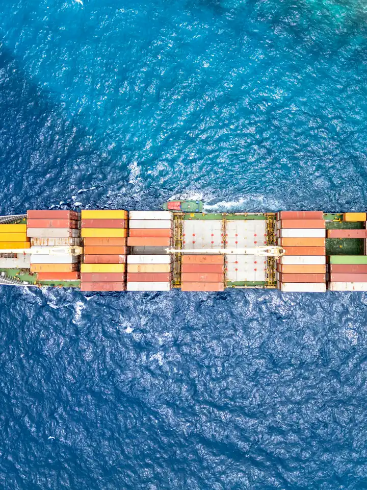 Aerial view of a container ship crossing turquoise water