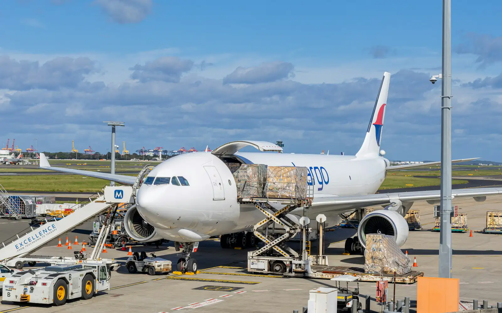 Cargo pallets being loaded into a freighter aircraft on the apron