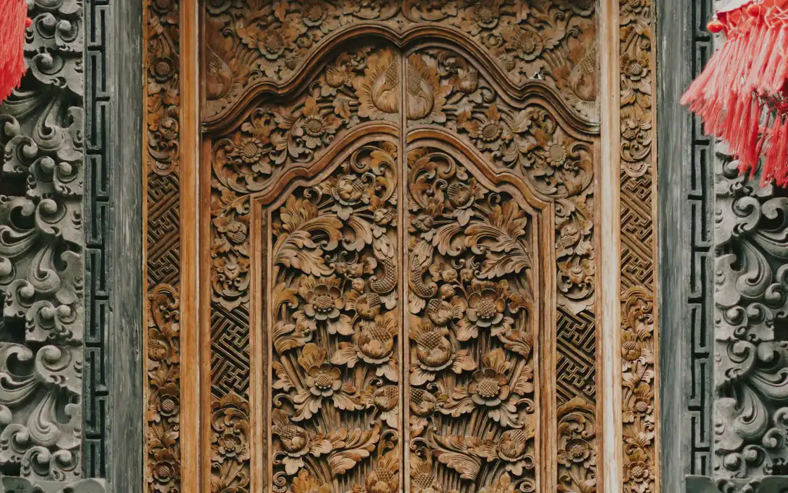 Ornate hand-carved Balinese wooden door, the kind of piece that travels in its own crate
